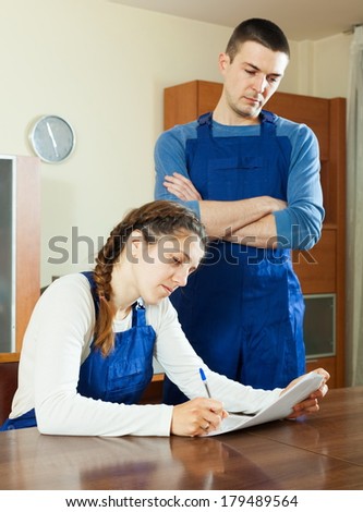 Workers in uniform reading financial documents at table