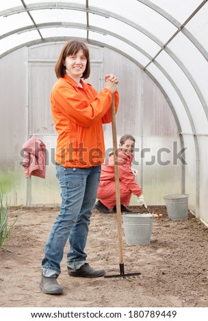 Happy women works at greenhouse in spring