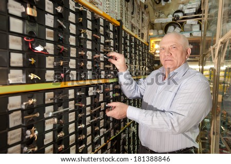 mature man chooses hardware in  auto spare parts store
