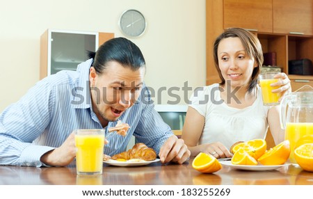 couple having breakfast with scrambled eggs  in morning after nighttime together. Focus on woman