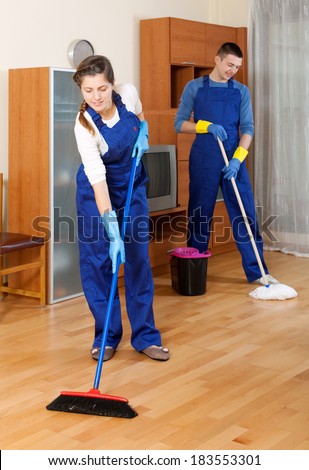 Man and woman cleaning in living room