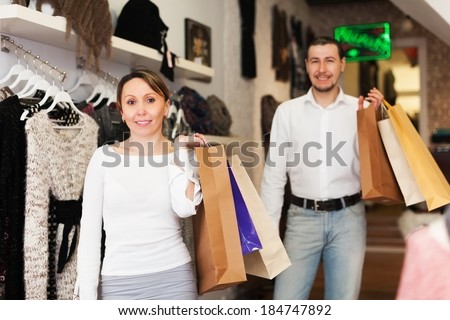 Couple with shop-bags at clothing boutique