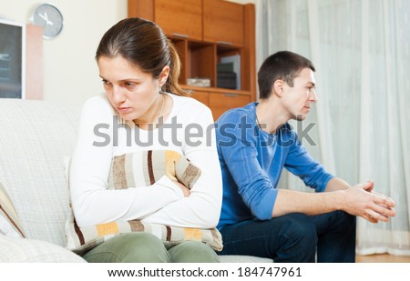 Family conflict. Sadness woman against unhappy man at home