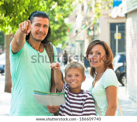 Middle-aged couple with teenage child traveling together at city street