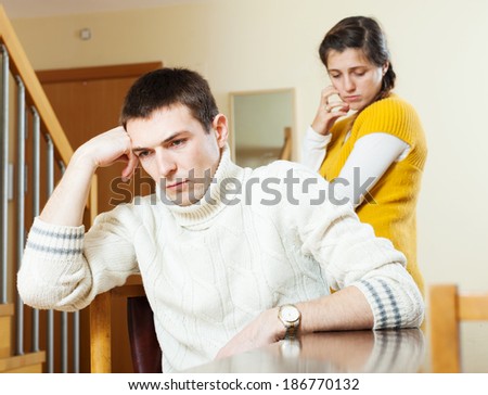 Upset ordinary man against unhappy woman  at home