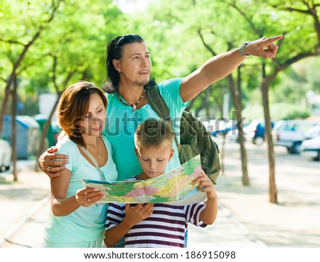 Man pointing the direction for wife and son at city
