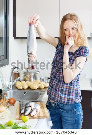 Young housewife  thinking how to cook seabass fish at kitchen
