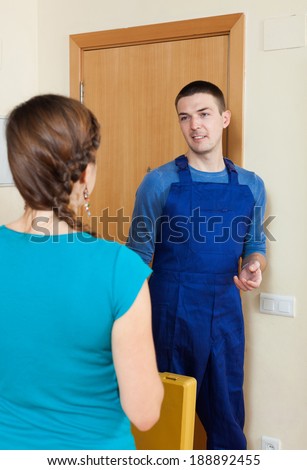 Young woman  meeting service worker at the door at home