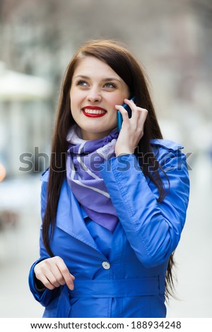 woman in blue cloak calling by mobile