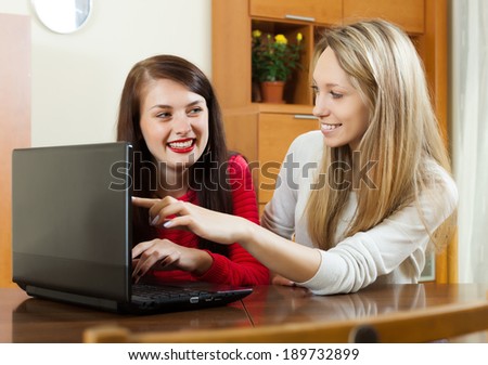 Happy women at table with laptop