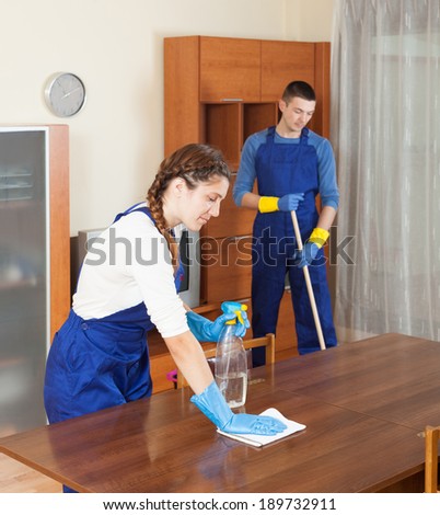 Team of professional cleaners cleaning in room at home