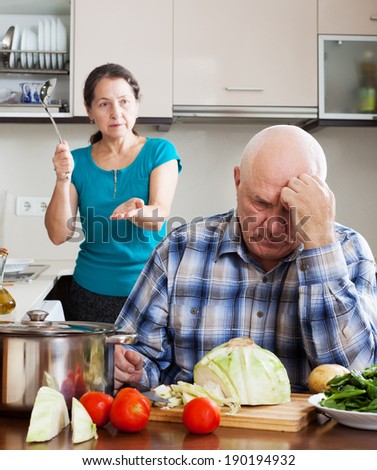 Sad mature guy and woman during quarrel  in kitchen at home