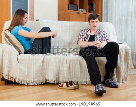 Family stress. Sad guy and girlfriend after quarrel  in living room at home