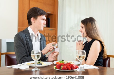 man gives jewelry pretty girlfriend during dinner