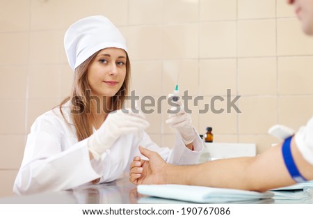 Positive nurse prepares to make an intravenous injection. Focus on woman