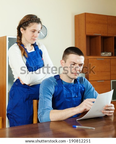 Workers in uniform reading financial documents