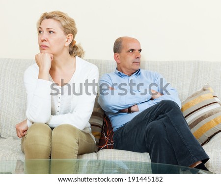 Sad  couple after quarrel in room at home