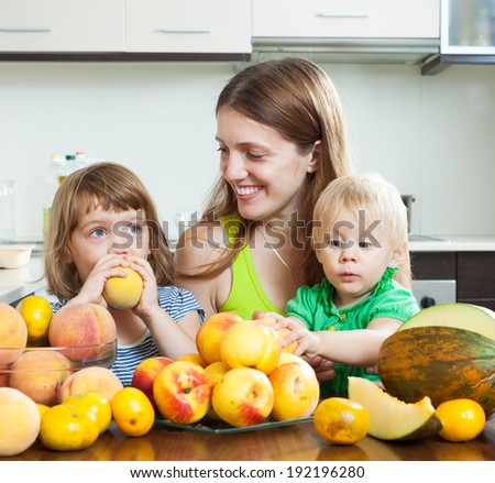 Smiling family together with melon and peaches over dining table at home interior