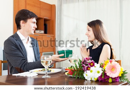 Man giving a gift to a girl for dinner