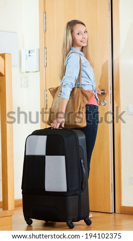 Attractive young woman with handbag and trunk going on leave