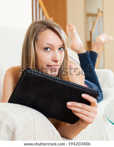 Charming girl browsing web with tablet at her rest-day