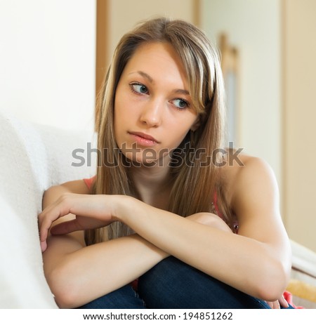 Sad   woman sitting on couch at home