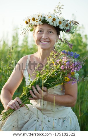 Outdoor portrait of mature  woman in camomile wreath