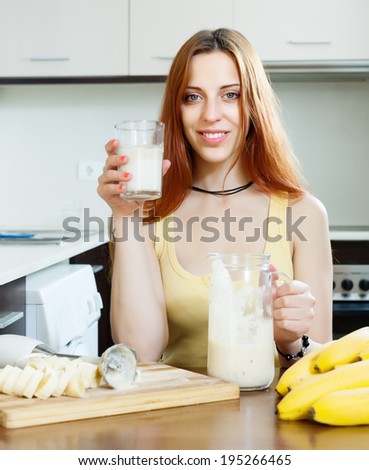 girl in yellow drinking fresh milk shake with bananas at home