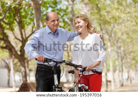 Elderly happy couple on summer weekends walking with bicycles