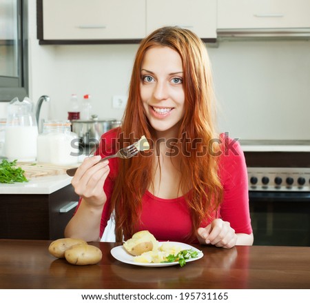 positive girl eating jacket potatoes at home interior