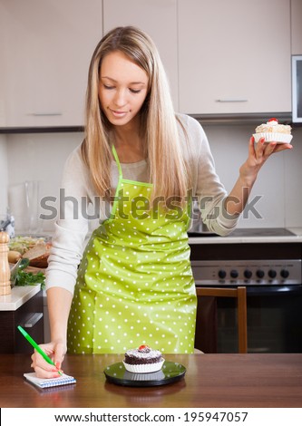 Woman  weighing cakes on kitchen scales