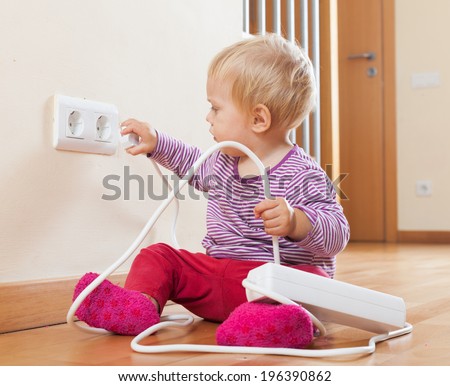 Toddler playing with extension cord at home
