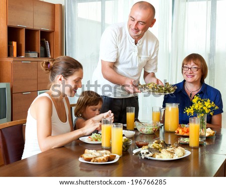 Happy multigeneration family together at home behind a table