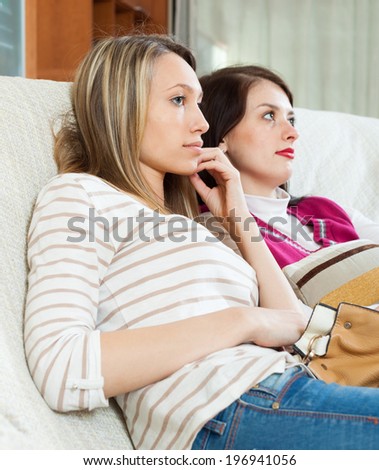 Sadness women together on sofa