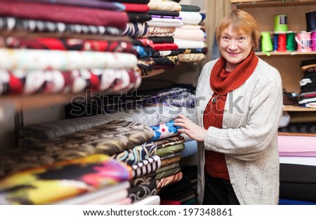 woman  chooses tissue at  fabric store