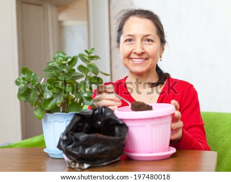 woman works with  flower pots at her home
