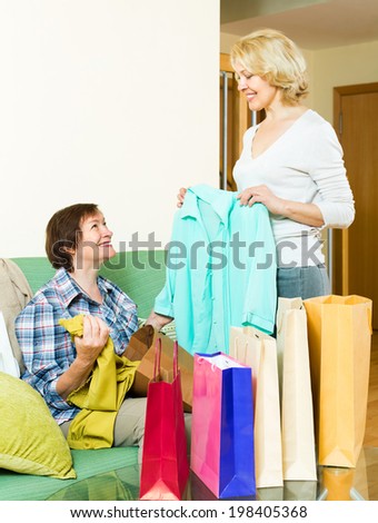 Mature woman showing her friend a new blouse after shopping
