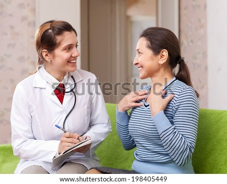 Happy doctor talks mature patient at hospital. Focus on patient