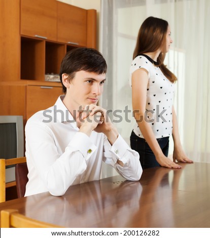 young couple having serious talking at table