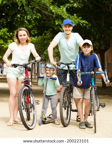 Active happy family staying with bicycles outdoor and smiling