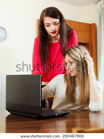 serious girls at table with notebook at office