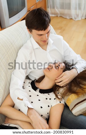 Loving young  couple on sofa in home