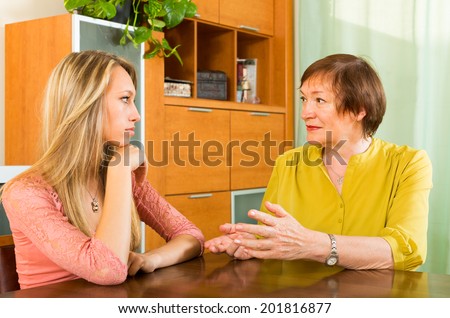 Aged mother having serious conversation with adult daughter