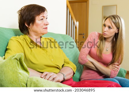 Senior woman and adult daughter having conflict at home. Focus on mature