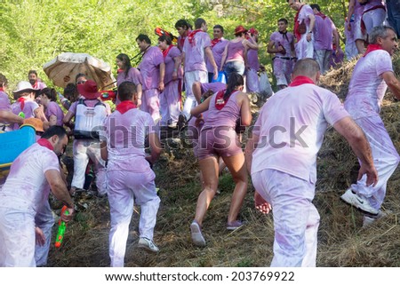 HARO, SPAIN - JUNE 29, 2014: Wet people at Haro Wine Festival (Batalla del vino). People pour wine at each other  from  bottles and buckets