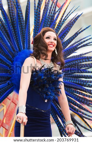 SITGES, SPAIN - JUNE 15, 2014: Woman in blue feathers at Gay pride parade in Sitges