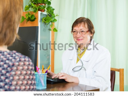 Mature doctor  communicates with patient sitting at PC