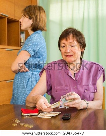Aged mother and her teen daughter having quarrel about money problems