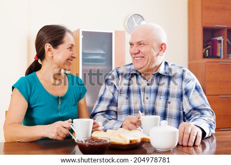 Happy mature couple having tea at home
