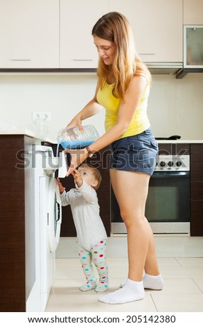 Family using washing machine with laundry detergent at home